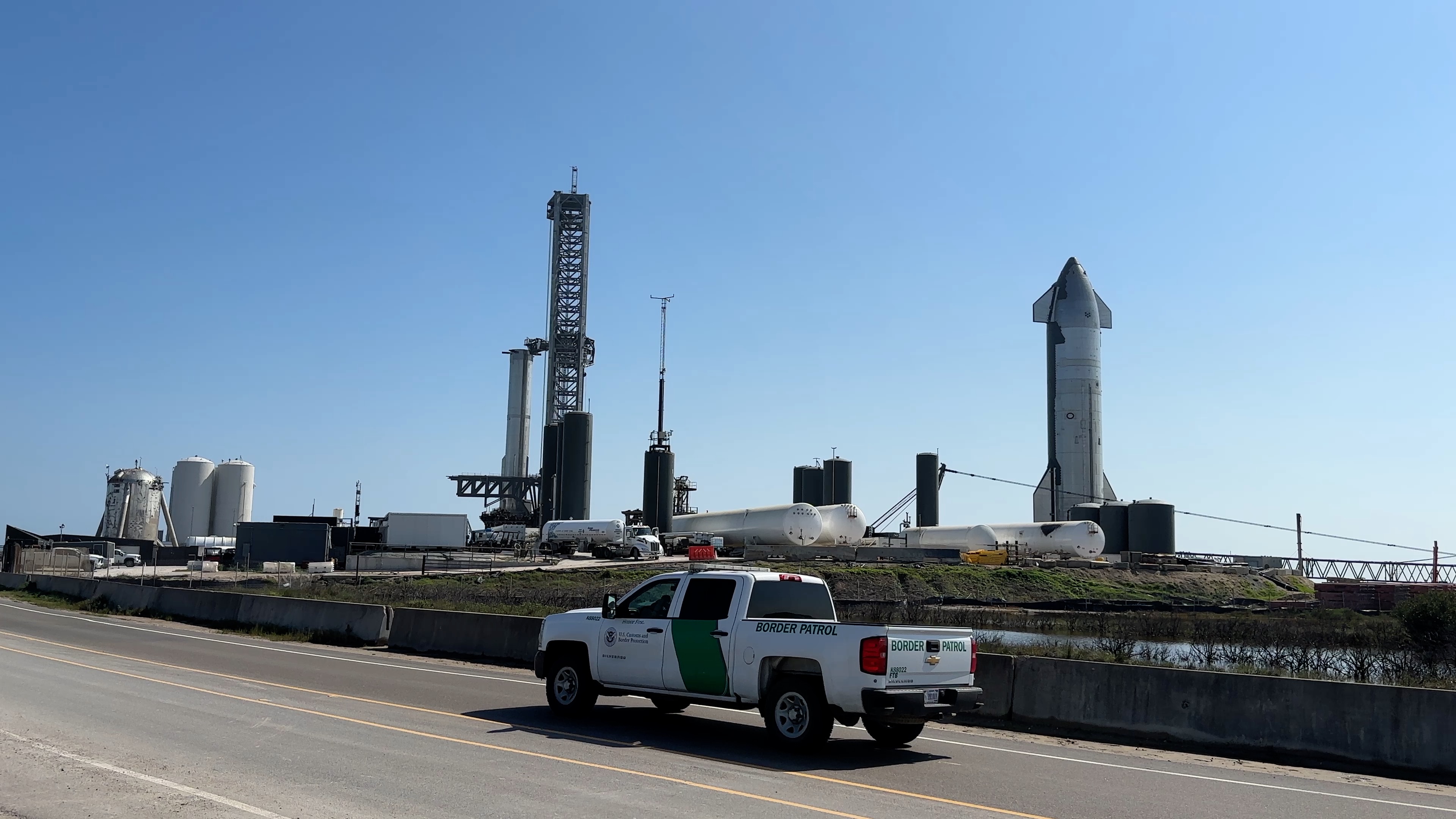 S25 odottaa lentovuoroaan moottorien koekäyttöpenkillä laukaisualueella. Super Heavy B7 on laukaisualustalla.